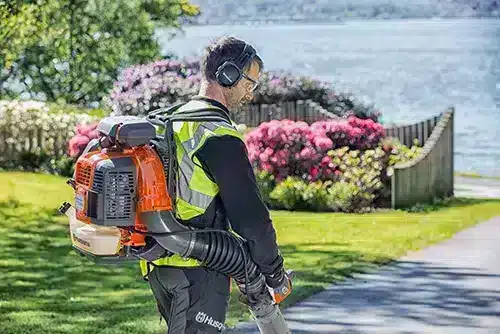 Image of a man using a Husqvarna backpack blower